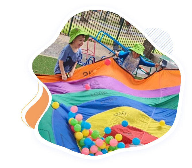 Happy kids playing with a colorful parachute during outdoor activities at the best pre-school in Seven Hills