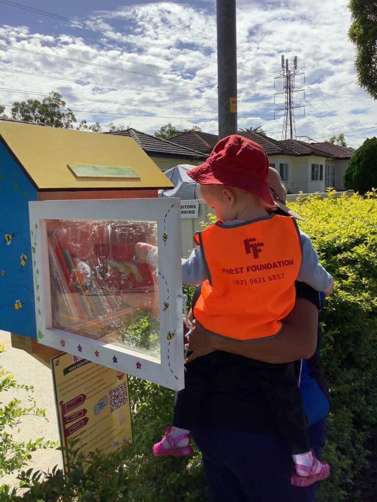 Child exploring books during outdoor preschool activity