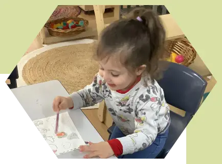 a little girl happily coloring in her book in our best daycare centre